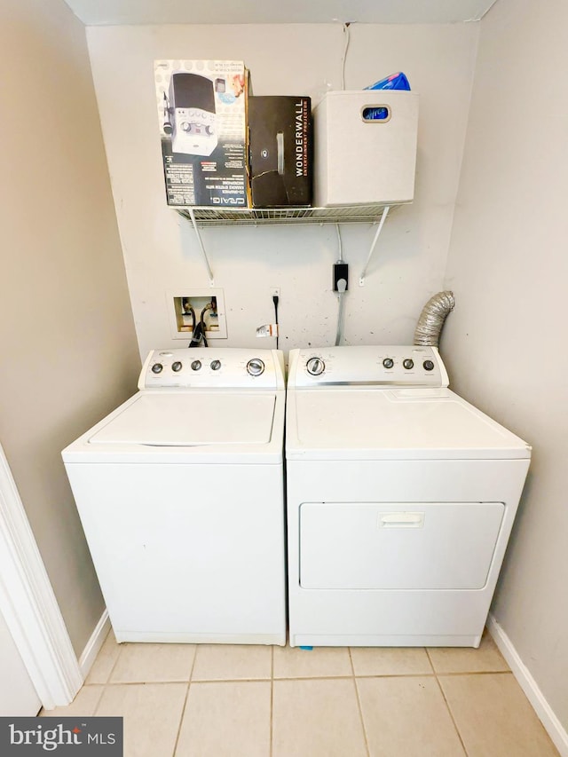 laundry room featuring washer and dryer and light tile patterned floors