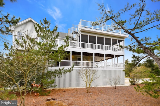 back of house with a sunroom and a wooden deck