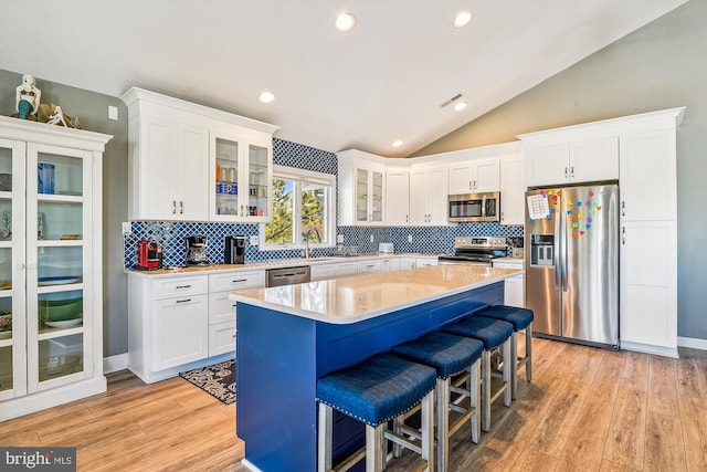 kitchen with appliances with stainless steel finishes, light hardwood / wood-style floors, and white cabinets