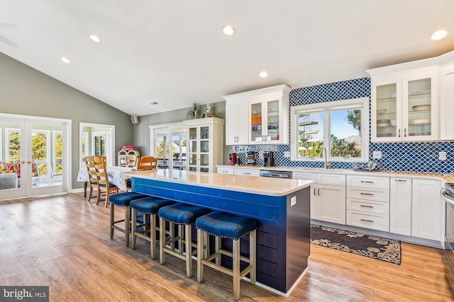 kitchen featuring white cabinets, a breakfast bar area, light wood-type flooring, and a kitchen island