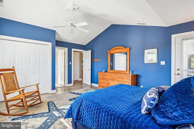 bedroom with a closet, a textured ceiling, hardwood / wood-style floors, lofted ceiling, and ceiling fan