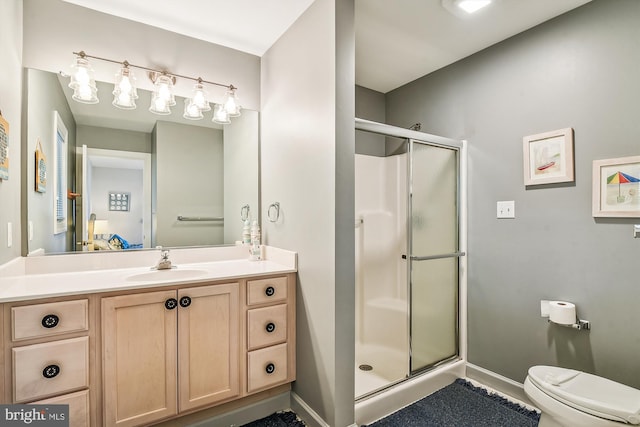 bathroom with vanity, toilet, and a shower with shower door