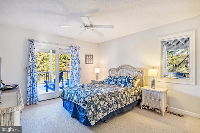 carpeted bedroom featuring access to exterior, a textured ceiling, and ceiling fan