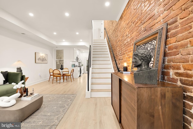 interior space featuring brick wall and light wood-type flooring