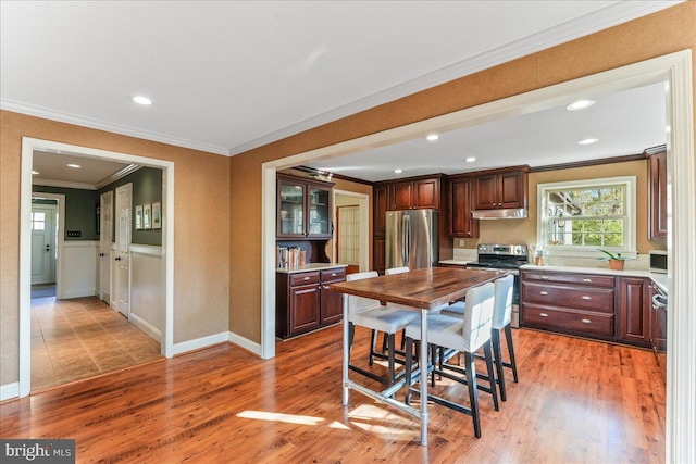 kitchen featuring ornamental molding, stainless steel appliances, and light wood-type flooring