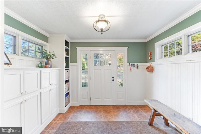 foyer entrance with crown molding, a textured ceiling, and plenty of natural light