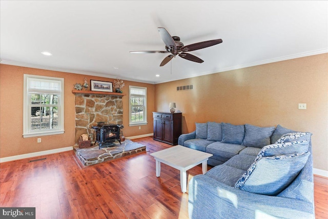 living room featuring a wood stove, hardwood / wood-style floors, and a healthy amount of sunlight