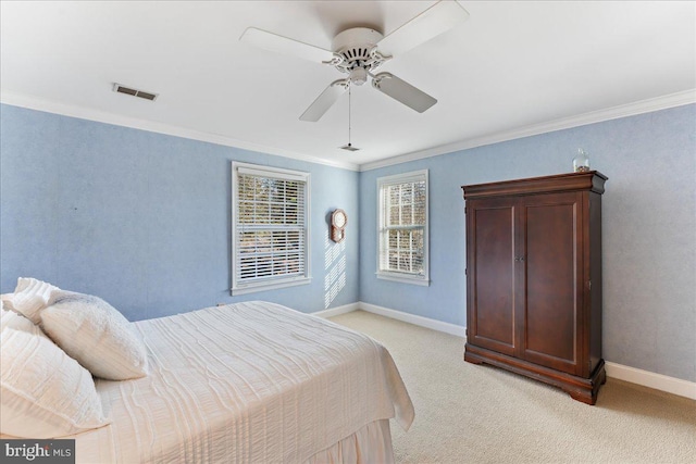 bedroom featuring ornamental molding, light colored carpet, and ceiling fan