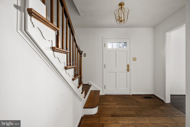 entryway featuring a chandelier and dark wood-type flooring