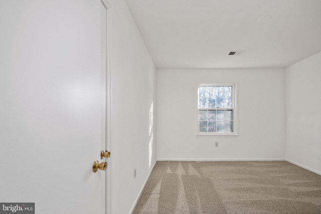 spare room featuring light colored carpet