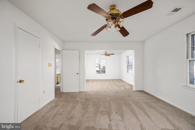 unfurnished living room with ceiling fan and light colored carpet