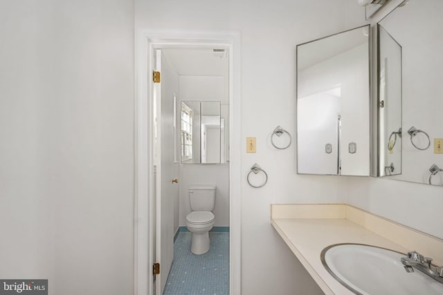 bathroom featuring toilet, sink, and tile patterned flooring