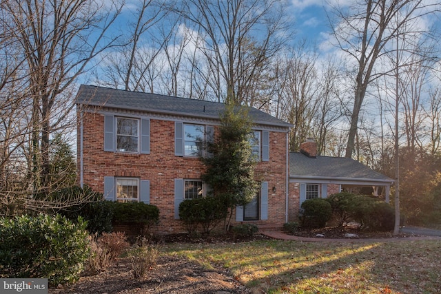 colonial inspired home featuring a front lawn