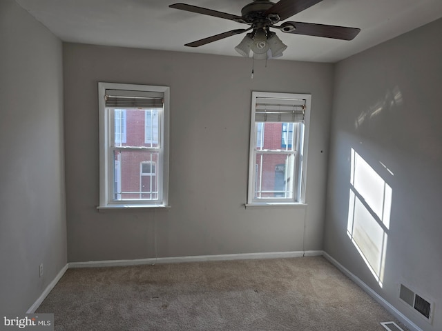 unfurnished room with light carpet, a healthy amount of sunlight, and ceiling fan