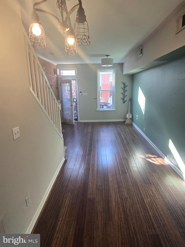 entrance foyer with dark wood-type flooring and a chandelier