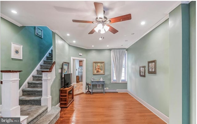 foyer featuring ornamental molding, a baseboard radiator, light wood-type flooring, and ceiling fan