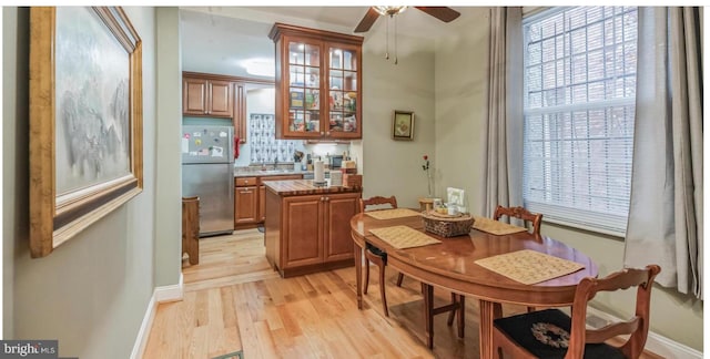 dining room featuring sink, ceiling fan, and light hardwood / wood-style flooring