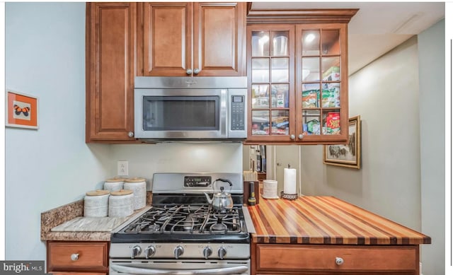 kitchen with wood counters and appliances with stainless steel finishes