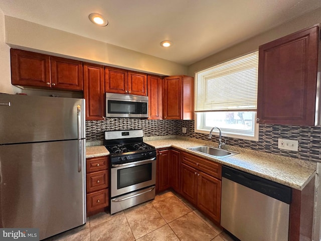 kitchen with backsplash, stainless steel appliances, sink, and light tile patterned floors