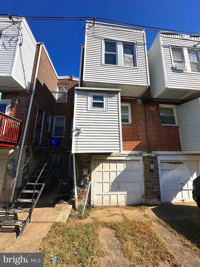 rear view of house with central AC unit and a garage