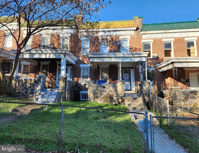 townhome / multi-family property featuring a porch and a front yard