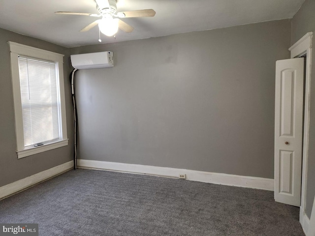 spare room featuring dark carpet, a wall unit AC, and ceiling fan