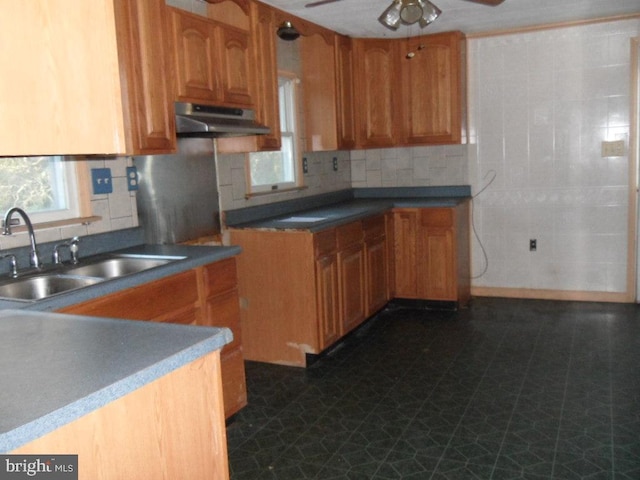 kitchen featuring ceiling fan, tasteful backsplash, sink, and dark tile patterned floors