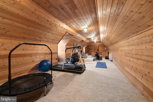 exercise room featuring carpet, vaulted ceiling, wooden ceiling, and wood walls