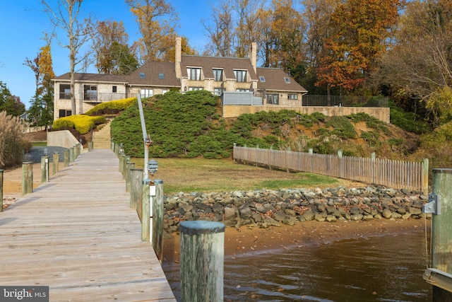 back of property with a yard and a water view