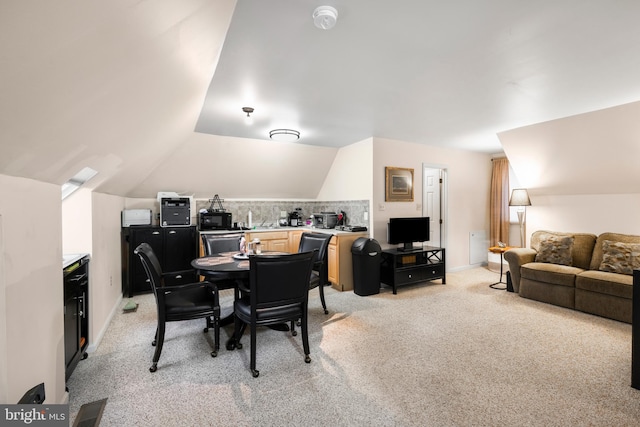 carpeted dining area featuring lofted ceiling