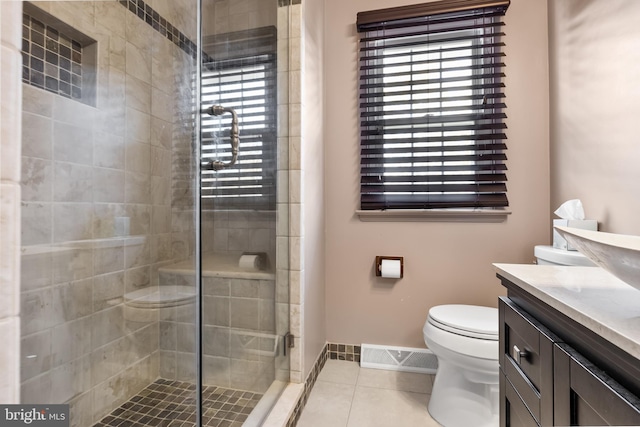 bathroom with toilet, tile patterned flooring, vanity, and a shower with door