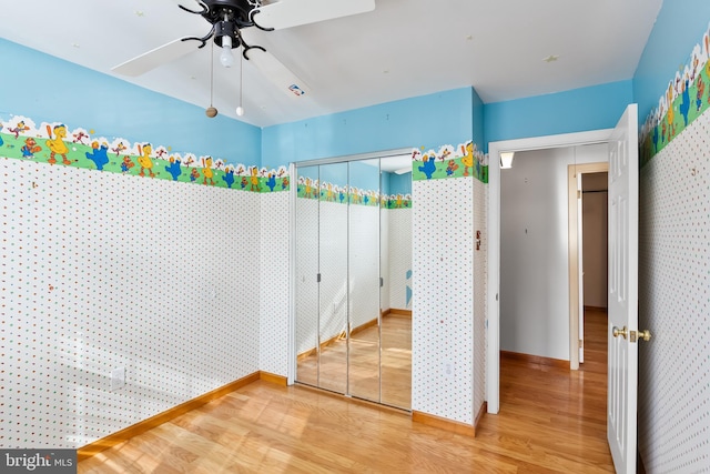 unfurnished bedroom with a closet, ceiling fan, and wood-type flooring