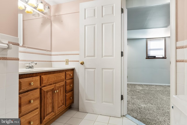 bathroom with tile walls, vanity, and tile patterned flooring