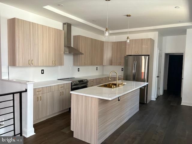 kitchen featuring dark hardwood / wood-style flooring, appliances with stainless steel finishes, a kitchen island with sink, wall chimney exhaust hood, and decorative light fixtures