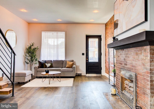 living room featuring a brick fireplace and hardwood / wood-style floors