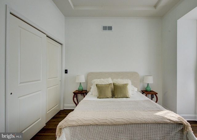 bedroom with a closet and dark hardwood / wood-style floors