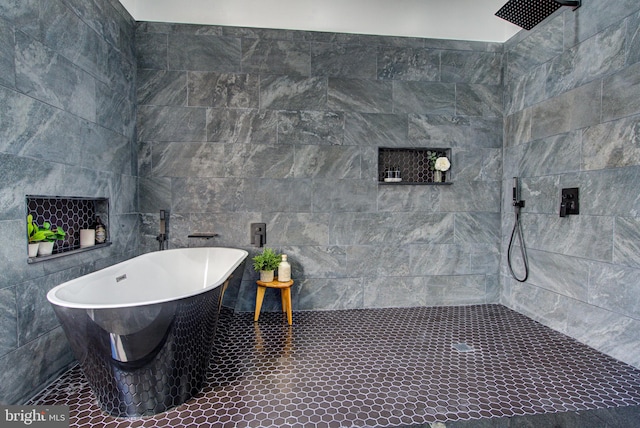 bathroom with tile walls and shower with separate bathtub