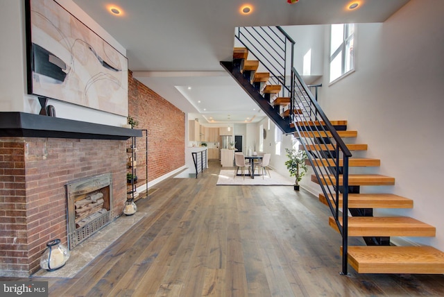 interior space featuring hardwood / wood-style floors, brick wall, and a fireplace