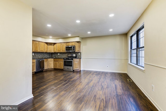 kitchen featuring dark wood-type flooring, appliances with stainless steel finishes, and decorative backsplash