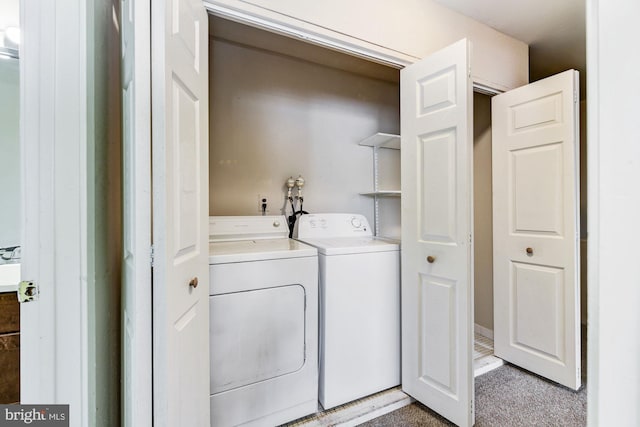 clothes washing area with light carpet and separate washer and dryer