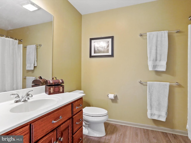 bathroom featuring toilet, vanity, and wood-type flooring