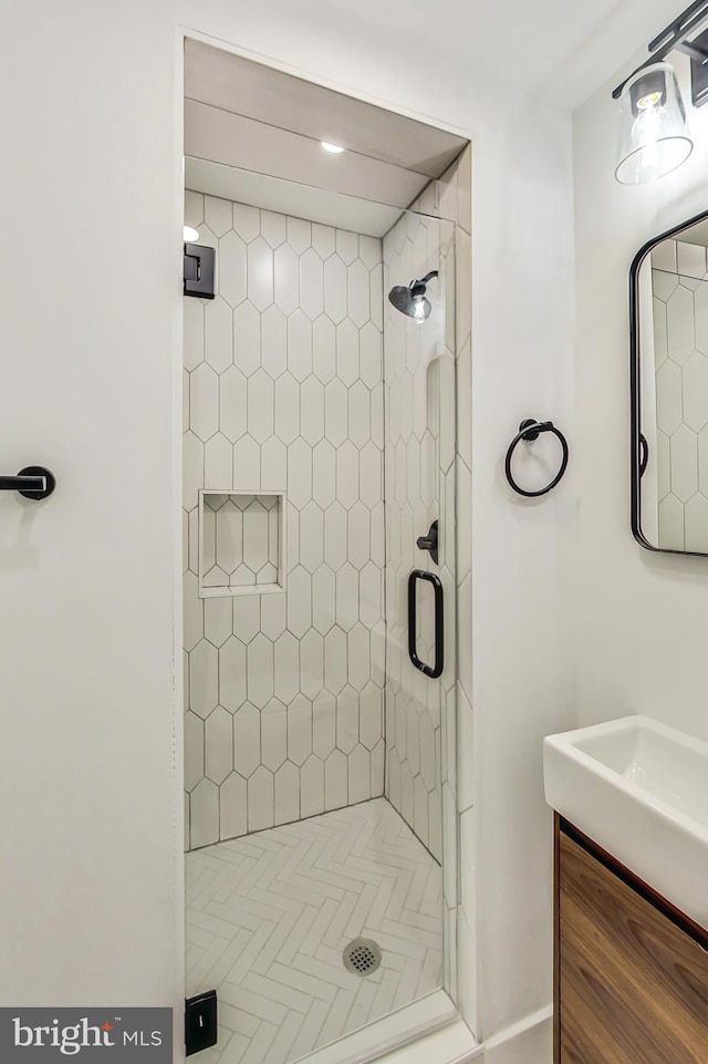 bathroom with vanity and tiled shower