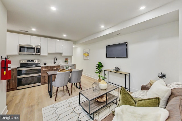 living room with light wood-type flooring and sink