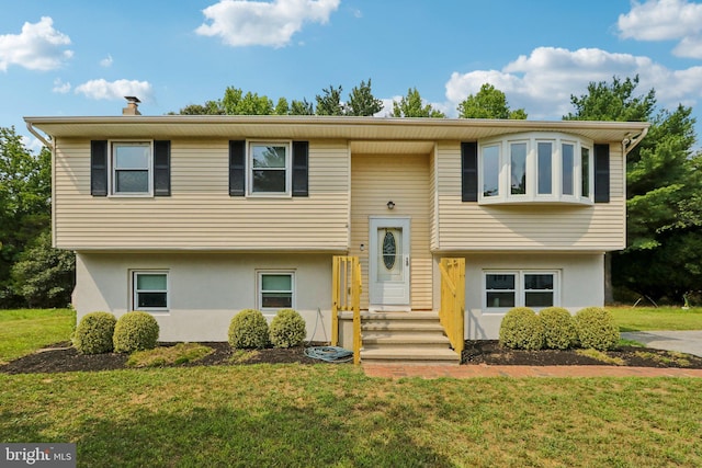 raised ranch featuring a front lawn