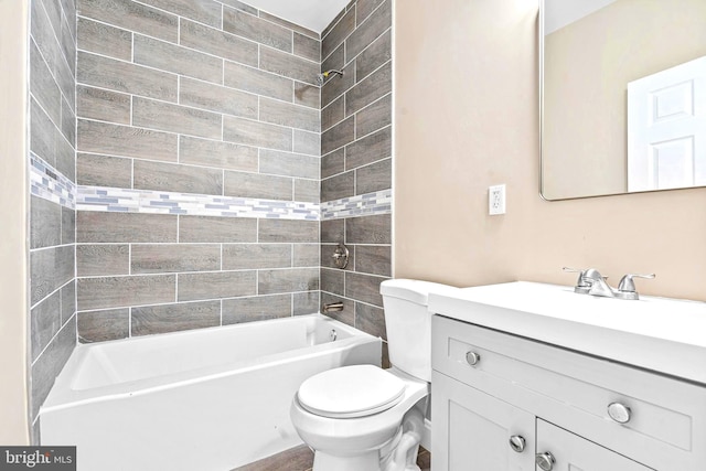 full bathroom featuring vanity, tiled shower / bath combo, and toilet