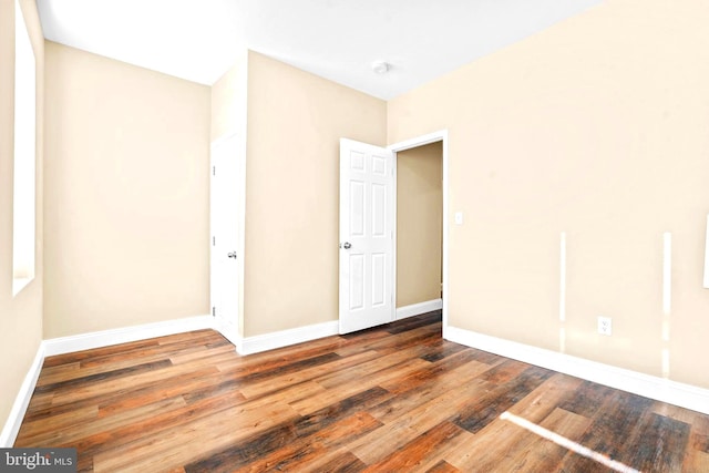 unfurnished bedroom featuring wood finished floors and baseboards