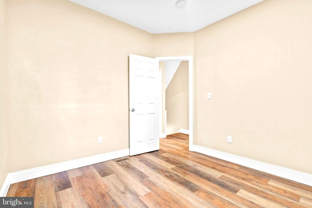 empty room featuring wood finished floors and baseboards