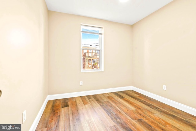 unfurnished room with wood finished floors and baseboards