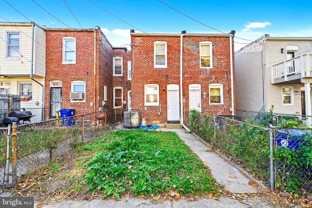 townhome / multi-family property with brick siding, a fenced backyard, and cooling unit