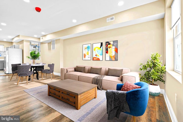 living room with wood finished floors, recessed lighting, visible vents, and baseboards